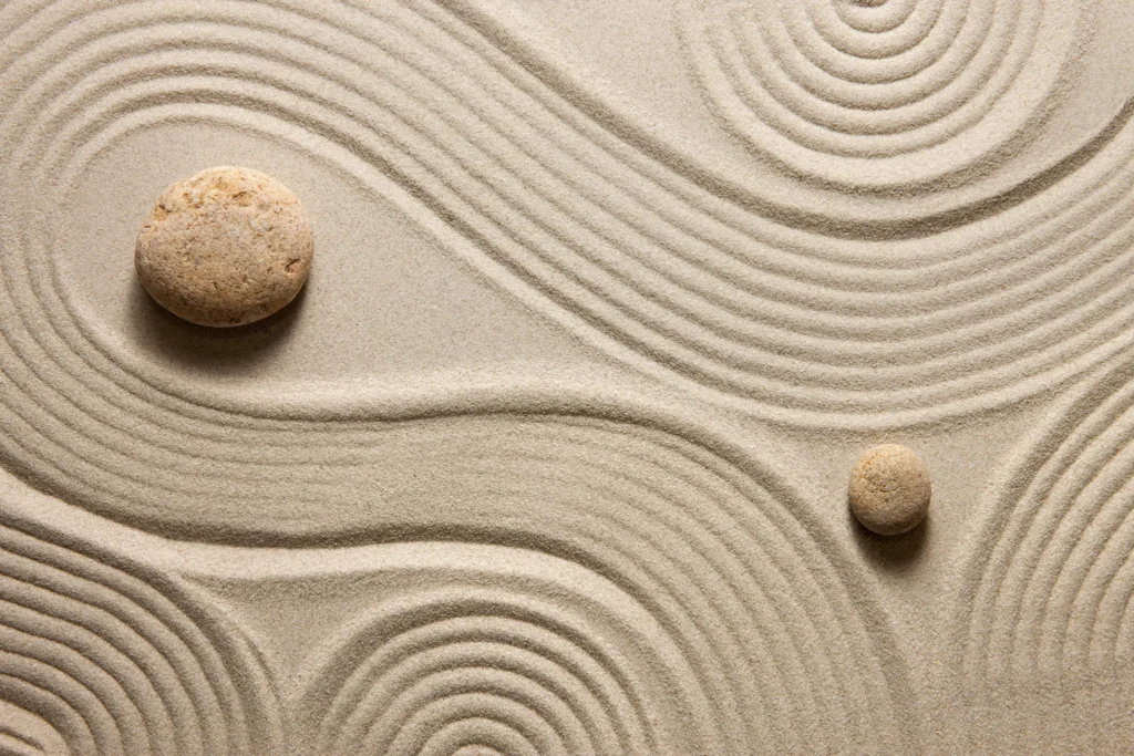 Räfflad sand med stenar i harmoniskt mönster – symboliserar Zen-förhandling och mental närvaro i förhandling