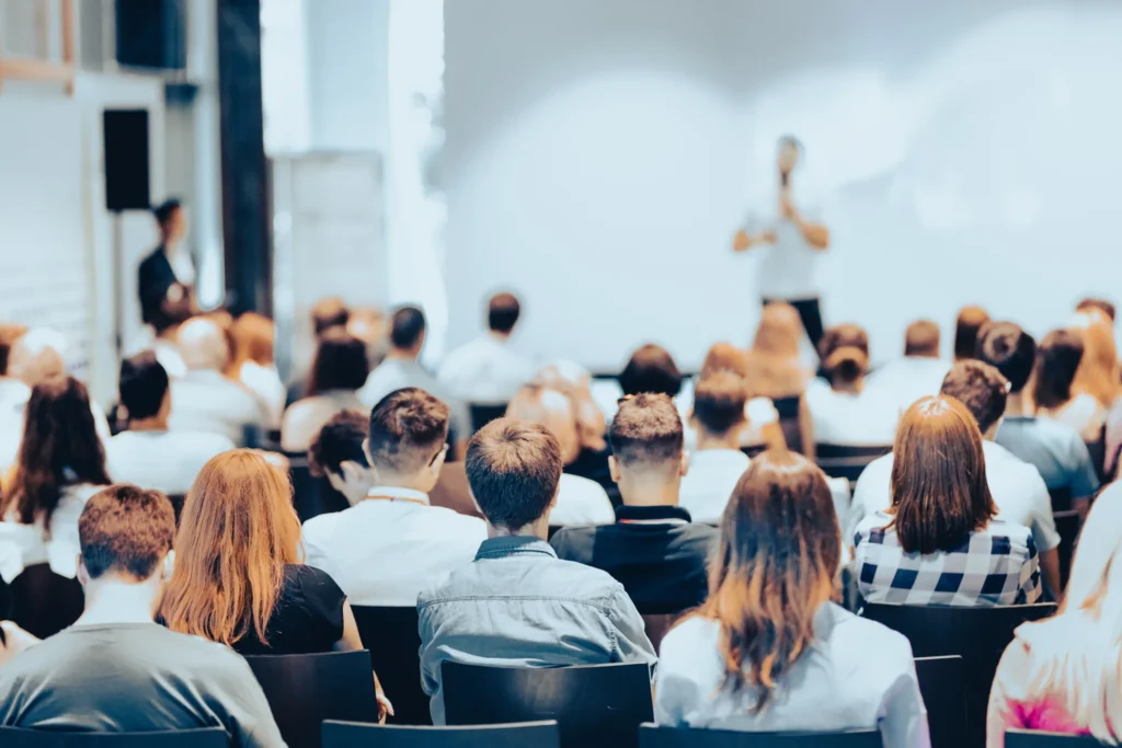 Deltagare som lyssnar på en föreläsning i en ljus konferenslokal under utbildning i professionell förhandlingsteknik och kommunikation.