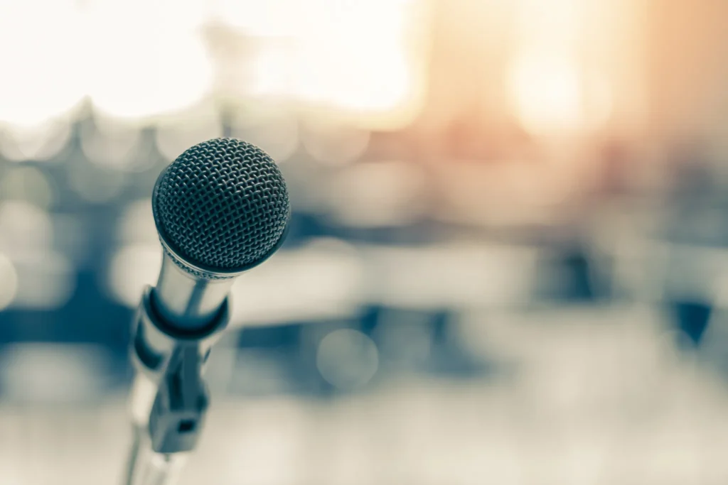 Närbild på mikrofon i varm belysning som förmedlar känslan av kommunikation, retorik och trygghet inför publik – en kurs i presentationsteknik från Yesbridge om att nå fram med sitt budskap.
