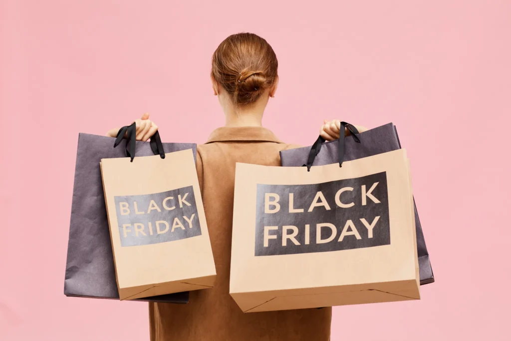 Person med shoppingpåsar märkta Black Friday – illustration av säljpsykologi och hur kampanjer påverkar beslut i köp och förhandling.