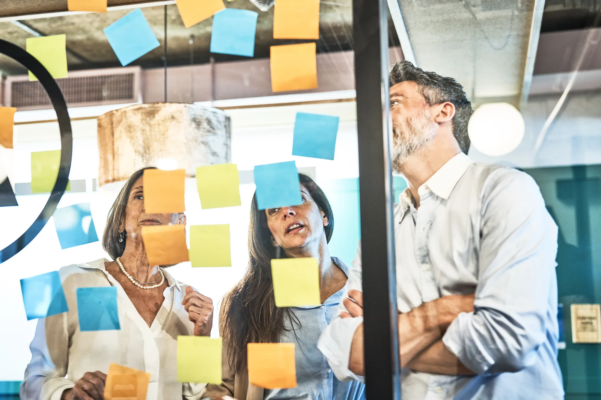 Deltagare arbetar med post-it-lappar på glasvägg under säljträning – workshop i
säljteknik och kundstrategi.