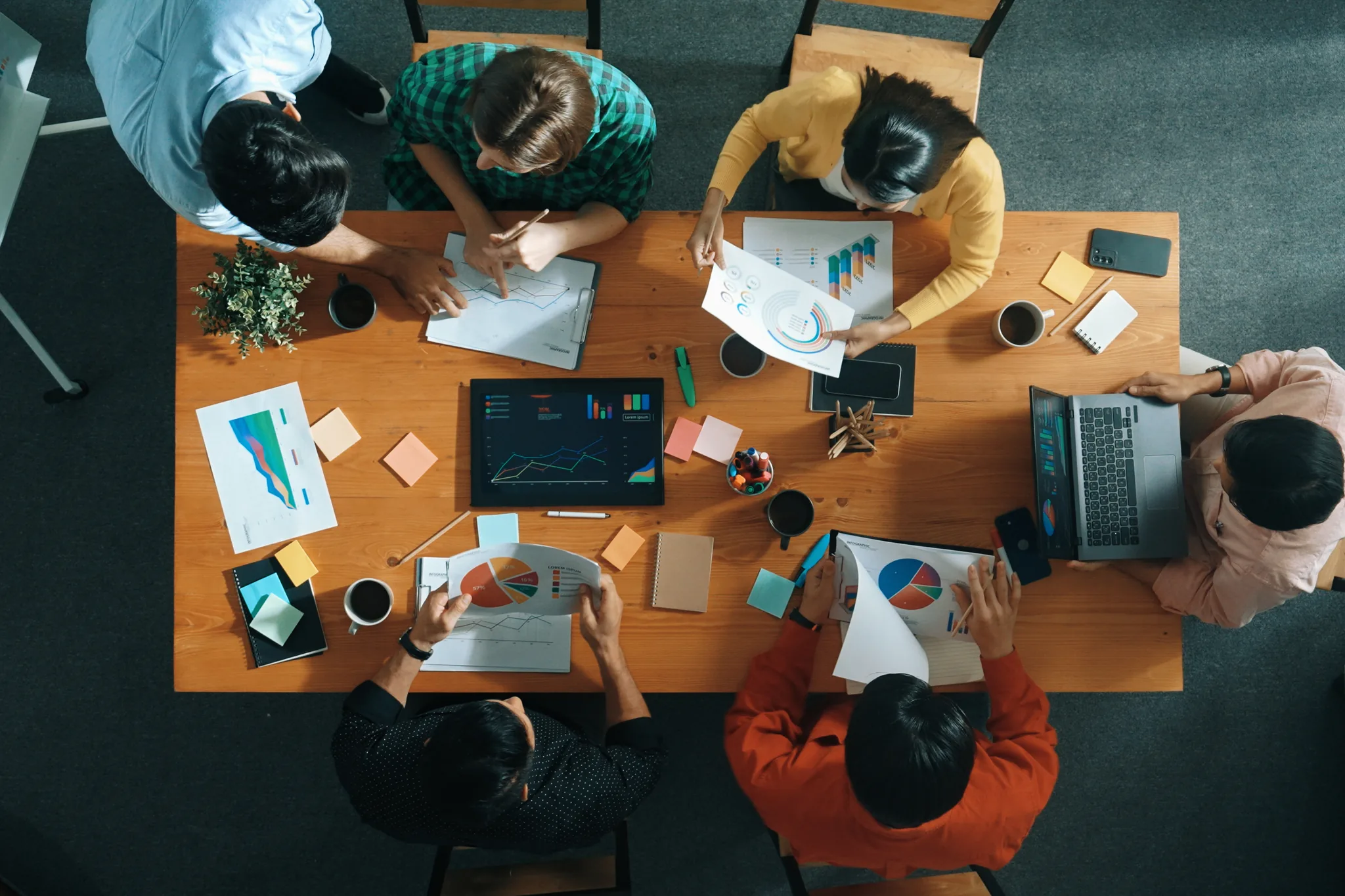 Team planerar upplägg vid bord med diagram och anteckningar – skräddarsydd
utbildning i förhandling och sälj.