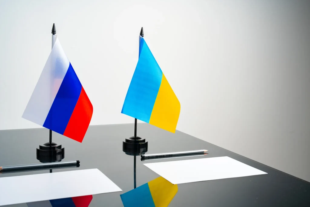 Bordsflaggor för Ryssland och Ukraina vid förhandlingsbord – symbol för fredsförhandlingar i kriget i Ukraina.